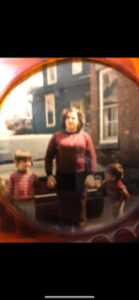 Vintage photo of a woman with two children outside a house.