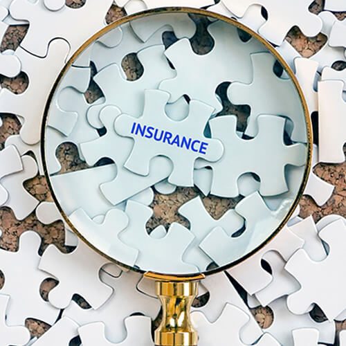 Magnifying glass highlighting the word 'INSURANCE' on puzzle pieces.