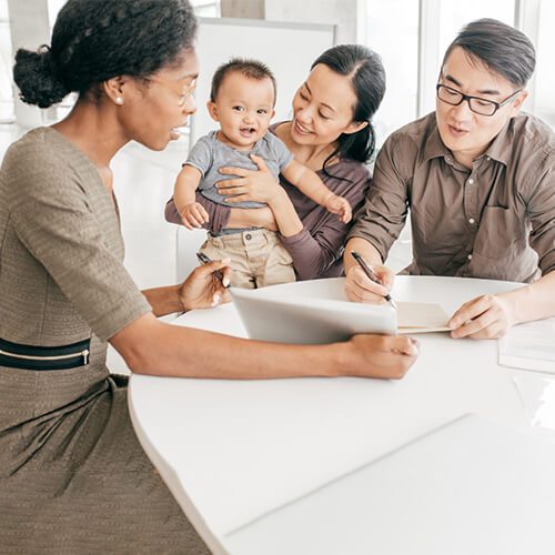Couple discusses finances with a professional holding their baby.