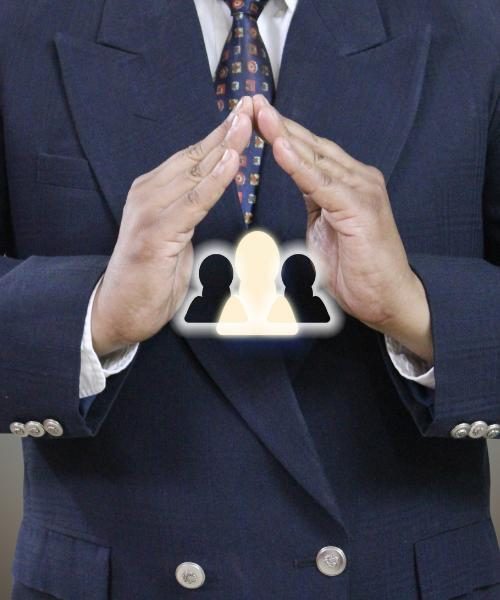 A person in a suit with their hands touching.